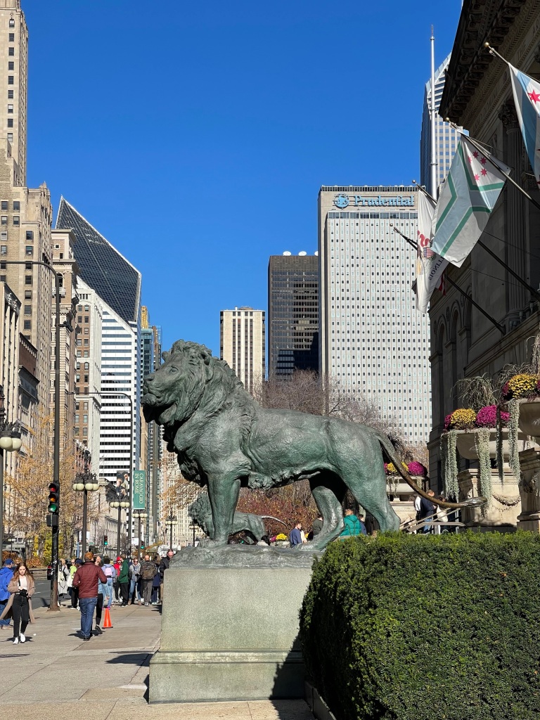 Photo of downtown Chicago, Illinois featuring one of the lion statues in from of the Art Institute of Chicago.