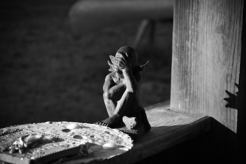 black and white photo of a gargoyle on a porch rail