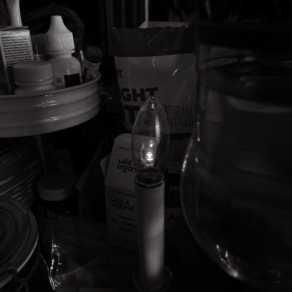 black and white photo of a battery operated candle on a kitchen countertop